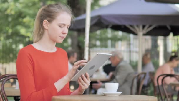 Mujer joven usando la tableta, sentada en la terraza del café — Vídeos de Stock