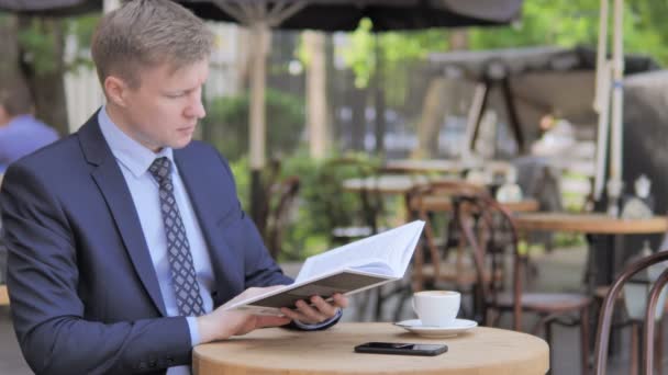 Відкритий сидячий бізнесмен читання книга — стокове відео