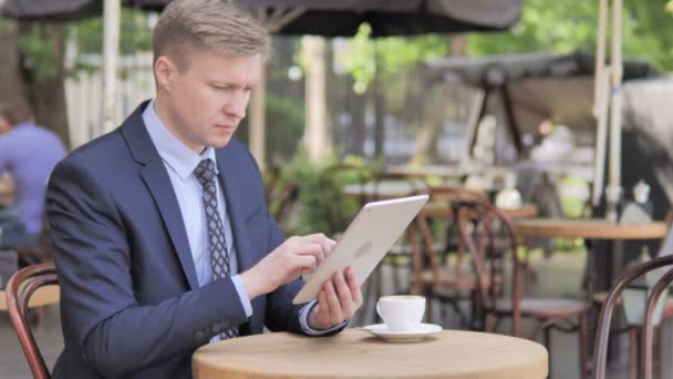 Empresario molesto por la pérdida en la tableta, sentado en el café al aire libre — Vídeo de stock