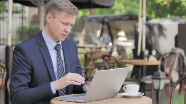 Affärsman med nacksmärta använda laptop utomhus — Stockvideo