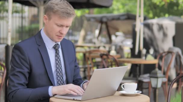 Empresario celebrando en el ordenador portátil en el café al aire libre — Vídeo de stock