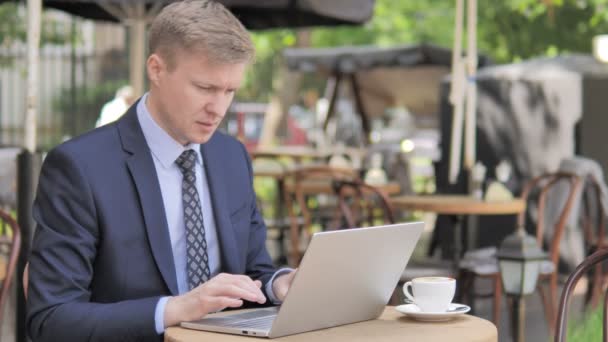 Biznesmen w Shock przez niepowodzenie na laptopie, outdoor Cafe — Wideo stockowe