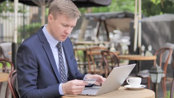 Erfolgreicher Online-Einkauf durch Geschäftsmann auf Caféterrasse — Stockvideo