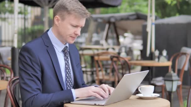 Empresário trabalhando no laptop e beber café no café ao ar livre — Vídeo de Stock