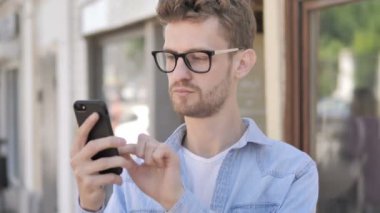 Casual Genç Adam Açık Kafe'de Oturan Smartphone Başarı Tezahürat
