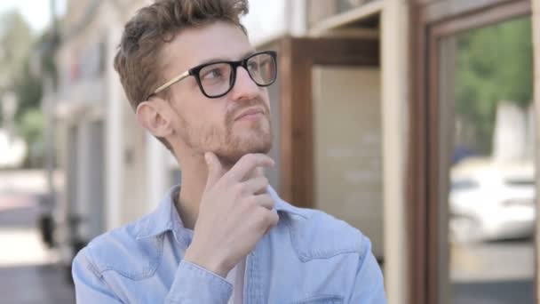 Pensando Casual Jovem Homem em pé ao ar livre — Vídeo de Stock