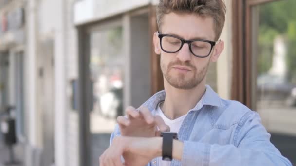 Lässiger junger Mann mit Smartwatch im Freien — Stockvideo