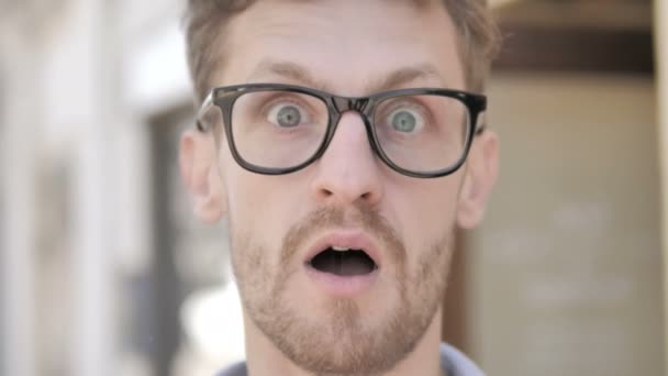 Outdoor close-up van geschokt jonge man in glazen — Stockvideo