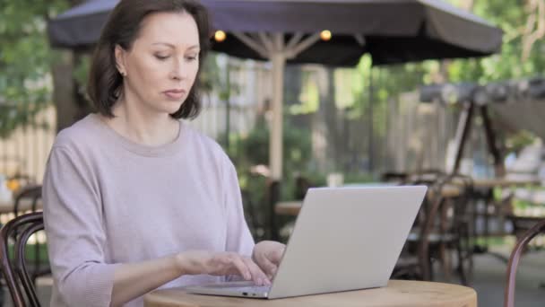 Stary kobieta siedzi na wolnym powietrzu i korzystanie laptop — Wideo stockowe