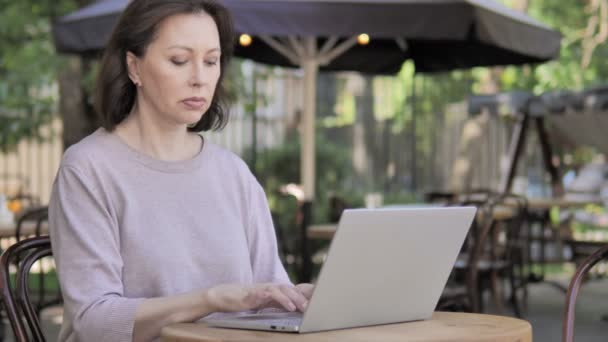 Vecchia donna con mal di schiena che lavora sul computer portatile all'aperto — Video Stock