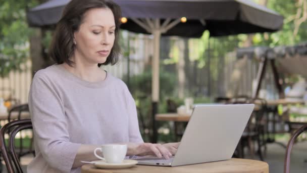 Al aire libre, anciana bebiendo café y trabajando en el ordenador portátil — Vídeos de Stock