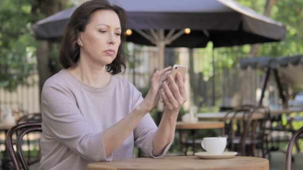Vieille femme en utilisant Smartphone assis dans un café extérieur — Video