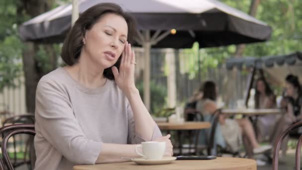 屋外カフェに座って頭痛を持つ老婦人 — ストック動画