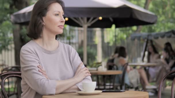 Glimlachend oude vrouw op zoek in de camera terwijl zittend in outdoor cafe — Stockvideo