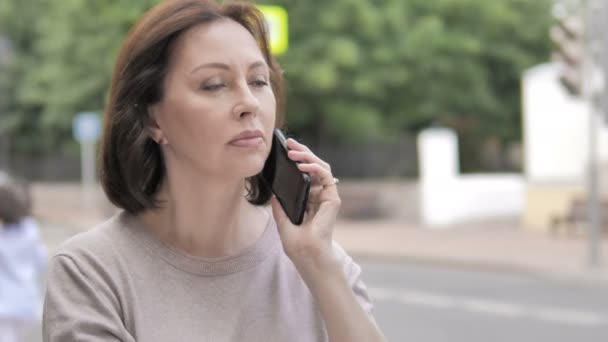 Anciana hablando por teléfono de pie al aire libre en el sendero — Vídeo de stock