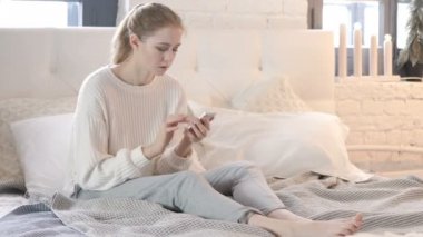 Yatakta Otururken Akıllı Telefon Kullanan Genç Kadın