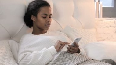 Yatakta Dinlenirken Akıllı Telefon Kullanan Genç Afrikalı Kadın