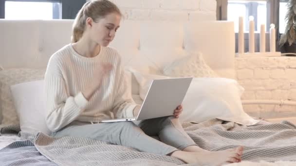 疲惫的年轻女子与颈部疼痛在床上的笔记本电脑工作 — 图库视频影像