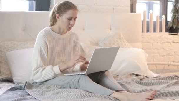 Втомлена жінка розслабляється, розтягує тіло під час використання ноутбука в ліжку — стокове відео