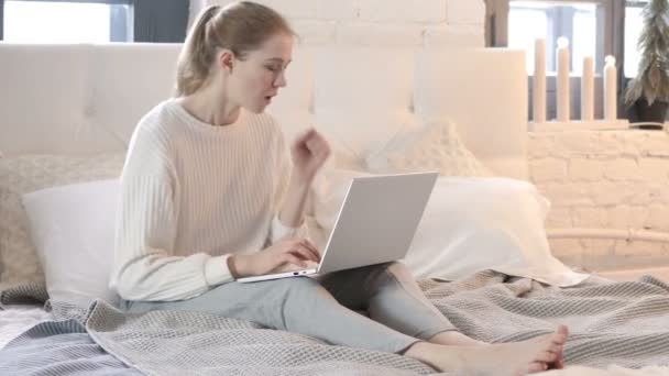 Mujer joven enferma tosiendo trabajando en el ordenador portátil, sentada en la cama — Vídeos de Stock