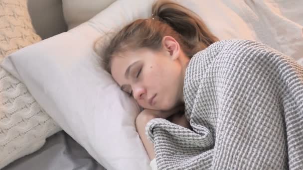ベッドで眠っている若い女性のトップビュー — ストック動画