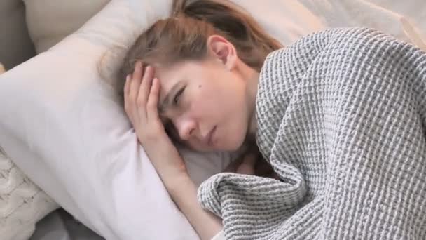 Вид сверху на встревоженную молодую женщину, пытающуюся спать в кровати — стоковое видео