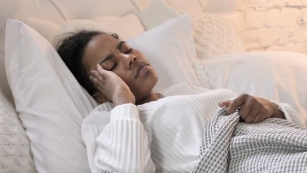 Mujer joven africana con dolor de cabeza acostada en la cama — Vídeos de Stock