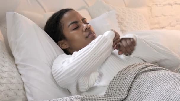 Joven mujer africana despertando por la mañana y estirando su cuerpo — Vídeos de Stock