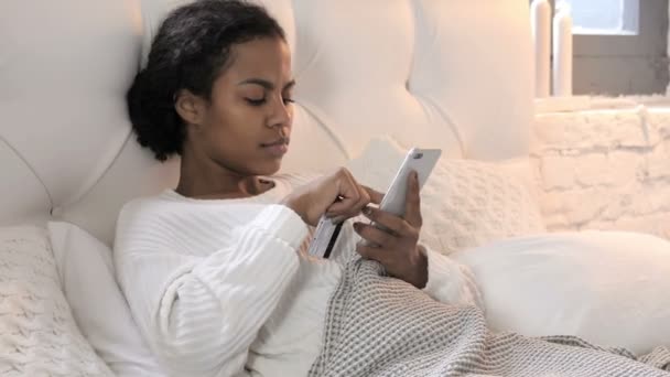 Compras en línea a través de Smartphone por Young African Woman Relajarse en la cama — Vídeos de Stock