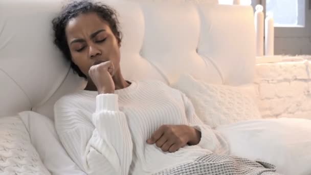 Kranke junge Afrikanerin hustet beim Entspannen im Bett — Stockvideo