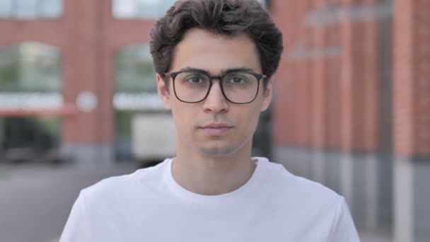 Utomhus porträtt av allvarliga ung man i glasögon — Stockvideo