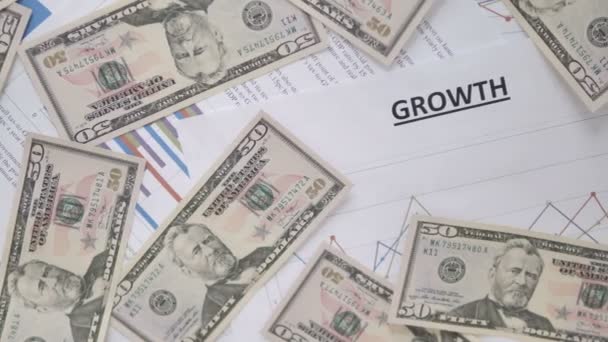 Розсіяні долари на діаграмі зростання на столі — стокове відео