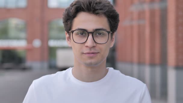 Retrato al aire libre del joven sonriente con gafas — Vídeos de Stock