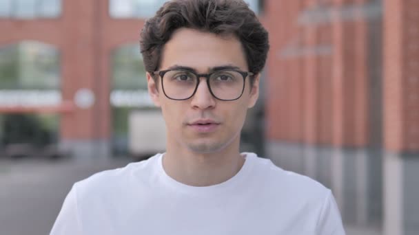 Портрет грустного молодого человека в очках — стоковое видео