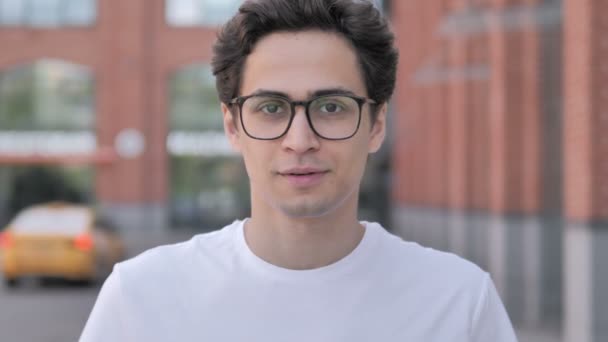 Ung man bjuder in nya människor medan de står utomhus — Stockvideo