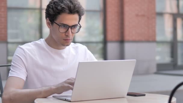 Pensamiento del joven pensante y trabajando en el ordenador portátil, al aire libre — Vídeos de Stock