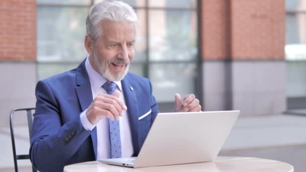Старый бизнесмен празднует успех на ноутбуке, на открытом воздухе — стоковое видео