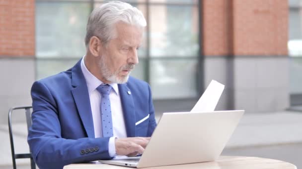 Alter Geschäftsmann arbeitet an Dokumenten und Laptop, im Freien — Stockvideo