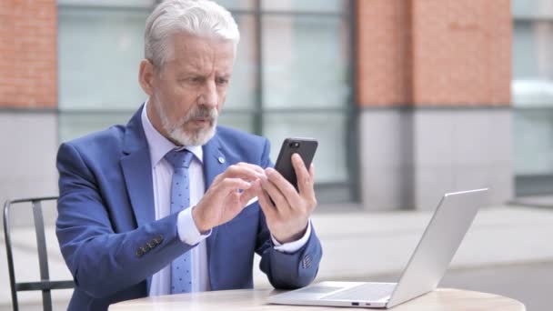 Vecchio imprenditore sconvolto dalla perdita durante l'utilizzo di smartphone — Video Stock