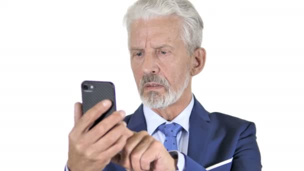Viejo hombre de negocios molesto por la pérdida en el teléfono inteligente, fondo blanco — Vídeos de Stock