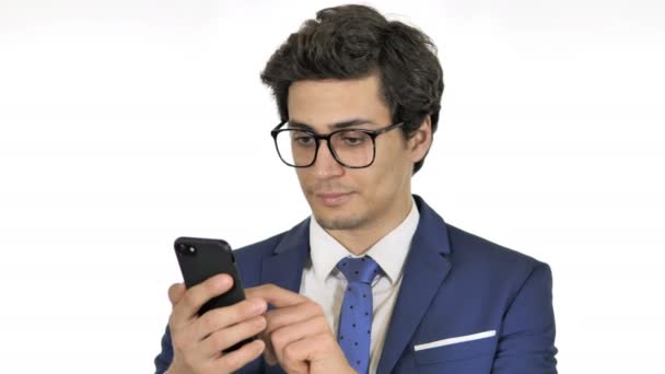 Jeune homme d'affaires utilisant un smartphone, fond blanc — Video