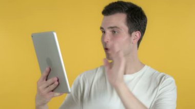 Tablet Izole üzerinden Genç Blogger tarafından Video Sohbet Sarı Arka Plan üzerinde Izole