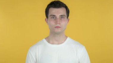 Genç Adam Sarı Arka Planda İzole Kameraya Bakıyor