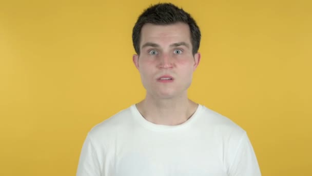 Молодой человек с разочарованием и гневом изолирован на жёлтом фоне — стоковое видео