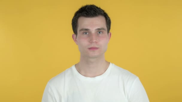 Handgemaakte hart door jonge man geïsoleerd op gele achtergrond — Stockvideo