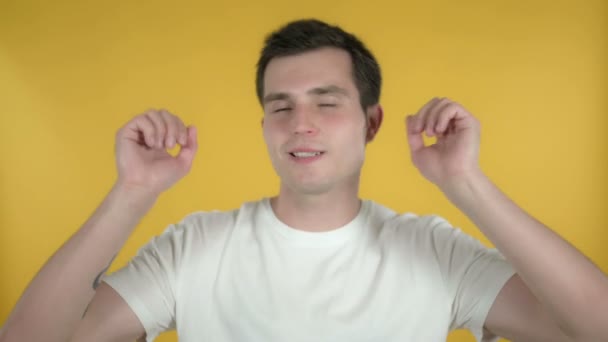 Gelukkige jonge man dansen geïsoleerd op gele achtergrond — Stockvideo