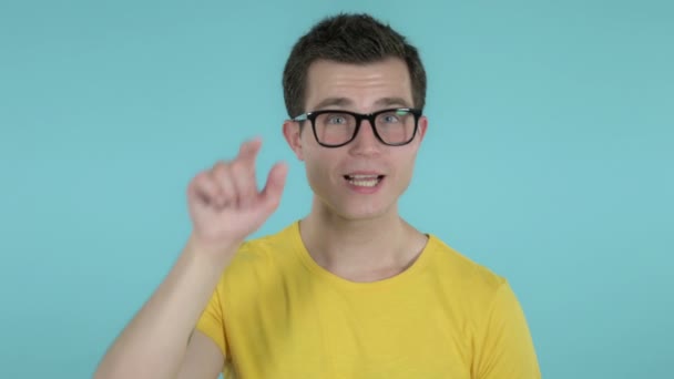 Jonge man die klanten uitnodigt met beide handen geïsoleerd op blauwe achtergrond — Stockvideo