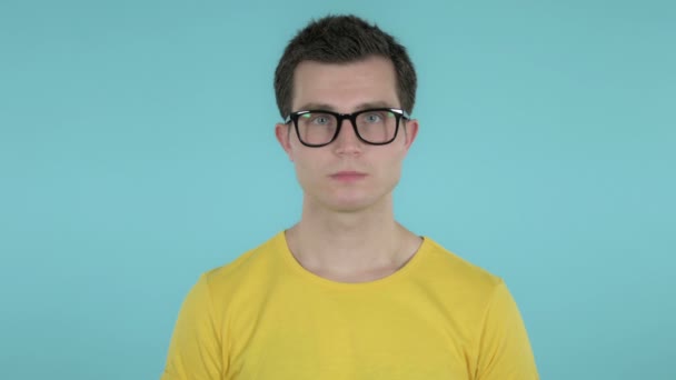 Junger Mann schüttelt den Kopf, um sich isoliert auf blauem Hintergrund zu verweigern — Stockvideo