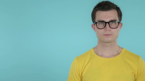 Junger Mann zeigt Produkt auf Seite, blauer Hintergrund — Stockvideo