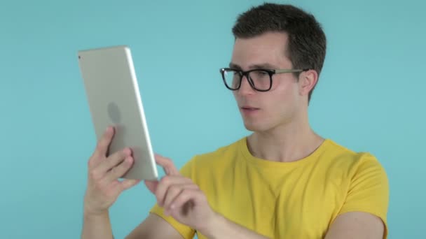 Jovem animado para o sucesso ao usar Tablet isolado em fundo azul — Vídeo de Stock